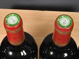six bottles of red wine in a wooden box on a table