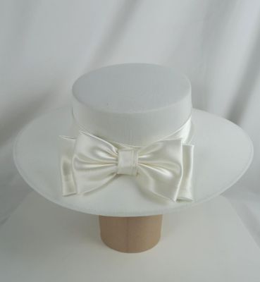 un chapeau blanc orné d'un nœud sur le dessus