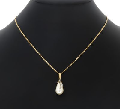 un collier en or avec un pendentif en perle autour du cou d'un mannequin