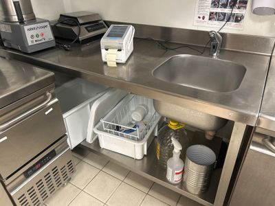 une cuisine équipée d'un évier et d'un plan de travail, avec beaucoup de vaisselle