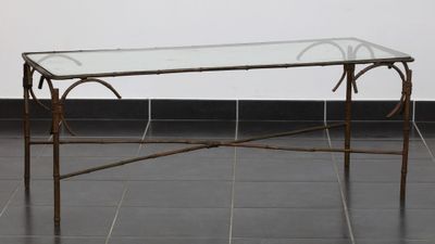 une table en verre avec un cadre en métal et un plateau en verre