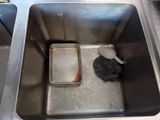a metal sink with a sponge and a container in it