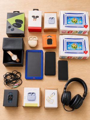 a lot of electronics and headphones laid out on a table