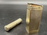 un briquet en or posé à côté d'un porte-briquet sur une table