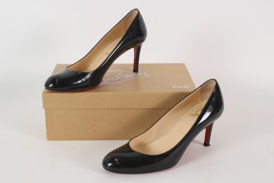 a pair of black high heels sitting on top of a box