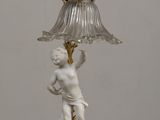 a lamp that is sitting on a table with a statue on it