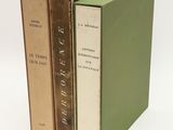 three books are stacked on top of each other on a white surface