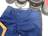 a pair of blue pants and a pair of black shoes next to a pair of baseball caps
