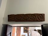 a wooden carving on the wall above a doorway
