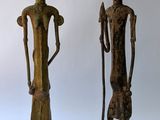 two wooden statues of a man and a woman standing next to each other