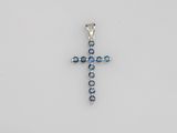 a cross pendant with blue crystals on a white background