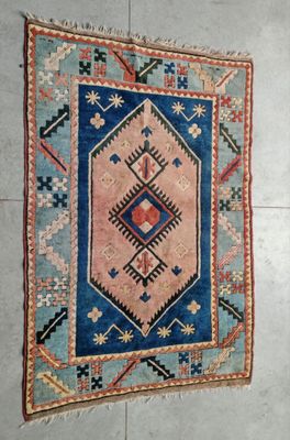 tapis posé au sol, orné d'un motif bleu et rose