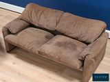 a brown couch that is sitting on a hard wood floor