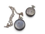 a silver pocket watch and a chain on a white surface