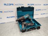 une perceuse électrique dans un coffret bleu posée sur une surface blanche