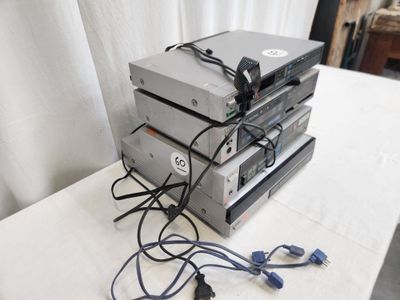 a stack of electronics sitting on a table next to a white curtain