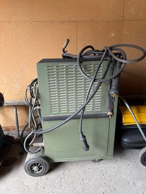 une petite machine verte posée à côté d'une valise noire