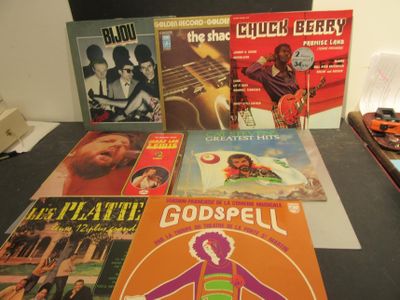 de nombreux livres de musique posés sur une table, à côté d'une guitare