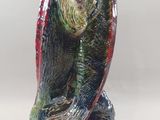 une figurine représentant un oiseau perché sur un rocher