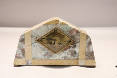 une horloge en marbre posée sur une table, avec un cadre doré
