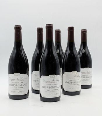 six bouteilles de vin sont alignées sur une surface blanche