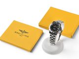 une montre noire et blanche posée sur une boîte jaune