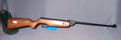 un gros plan d'un fusil sur fond blanc, avec une arme à feu au premier plan
