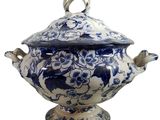 a blue and white vase with a lid on a stand