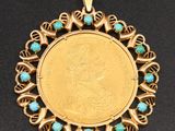 un pendentif en forme de pièce d'or orné de perles de turquoise sur un fond noir