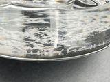 a glass container with a silver lid on a table