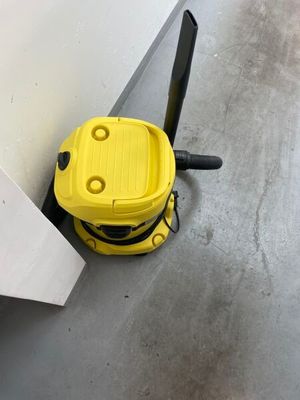 un aspirateur jaune posé par terre près d'un mur