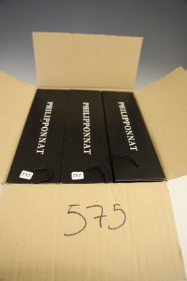 une boîte contenant trois livres, posée sur une table