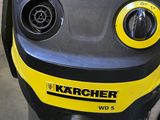 a yellow and black vacuum on the floor next to a red box