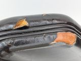 a close up of a black purse with holes in it