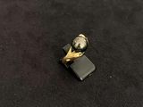 a small black and gold ring on a black surface