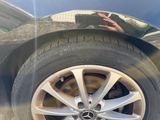a close up of a car ' s tire with a reflection of a person in the mirror