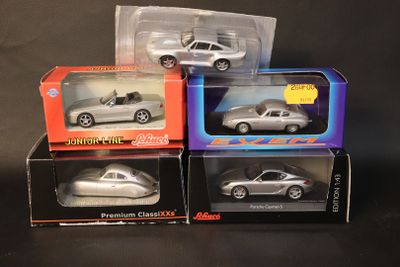 three silver cars are sitting in boxes on a black surface