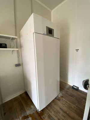 un réfrigérateur blanc dans le coin d'une pièce