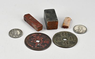 plusieurs types de pièces de monnaie et un bloc en bois posés sur une surface blanche