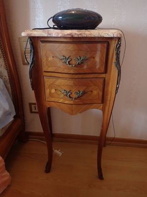 une petite table sur laquelle est posé un bol, à côté d'un lit