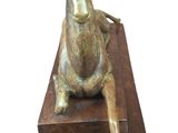 bronze statue of a horse on a wooden block with a white background