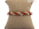 a close up of a pillow on a pillow with a bracelet on it