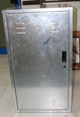 a metal cabinet sitting on a tile floor in a room