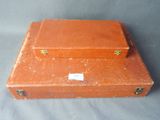 a small orange suitcase sitting on a gray surface