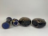 three black and gold vases sitting next to each other on a white surface