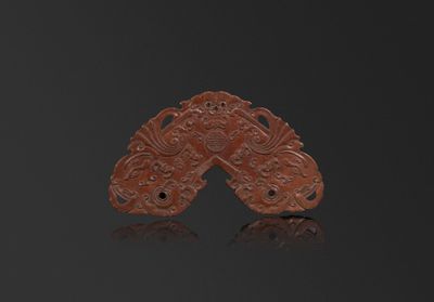 une image représentant une paire de boucles d'oreilles en jade rouge sculpté