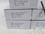 four boxes of new and unused drill bits are sitting on a table