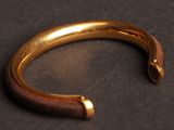 a close up of a gold bracelet on a black surface