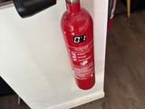 a red fire extinguisor attached to a white wall
