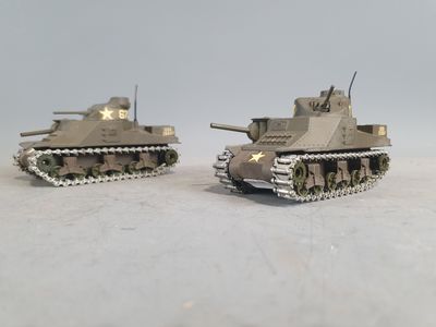 two toy tanks sitting side by side on a table